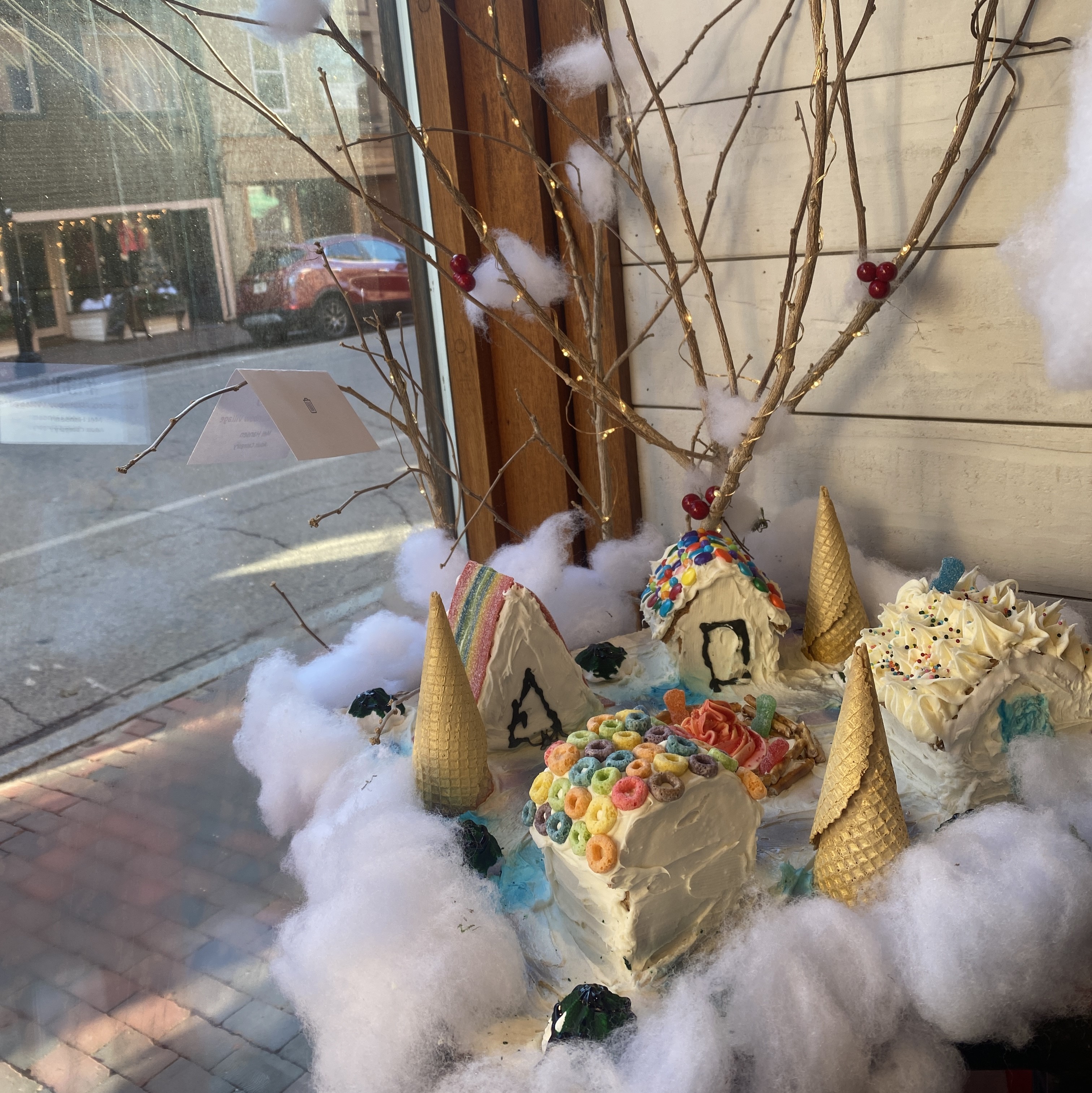 A gingerbread house in a storefront window