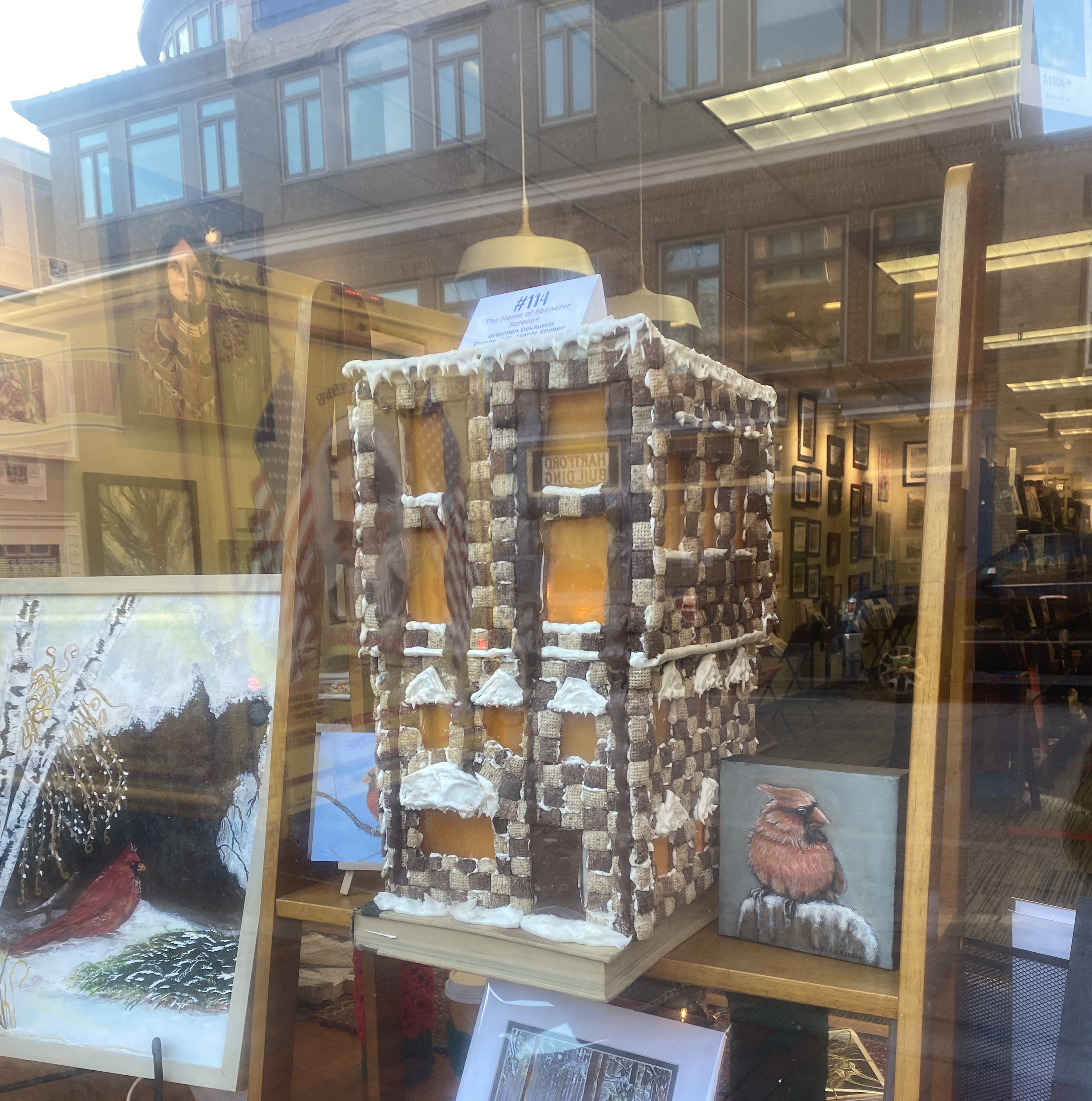 A gingerbread house in a storefront window