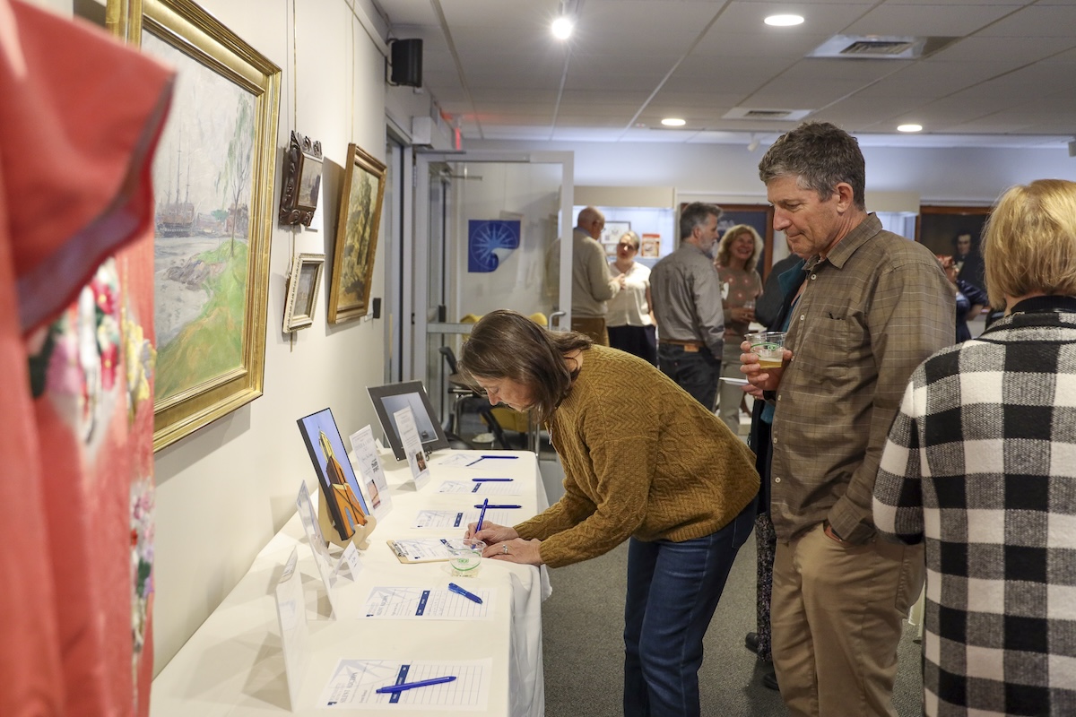 Two people bid on items at the Portsmouth Historical Society silent auction.
