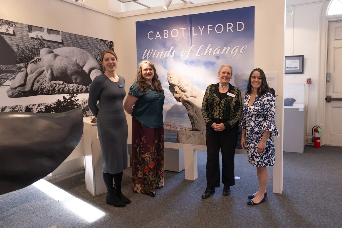 Title panel for “Cabot Lyford: Winds of Change” featuring Lyford’s most famous Portsmouth sculpture, My Mother the Wind, with Executive Director Emma Stratton, Exhibitions Manager Meredith Affleck, Lyford family member Julia Lane, and Guest Curator Rachel Walls (left to right).